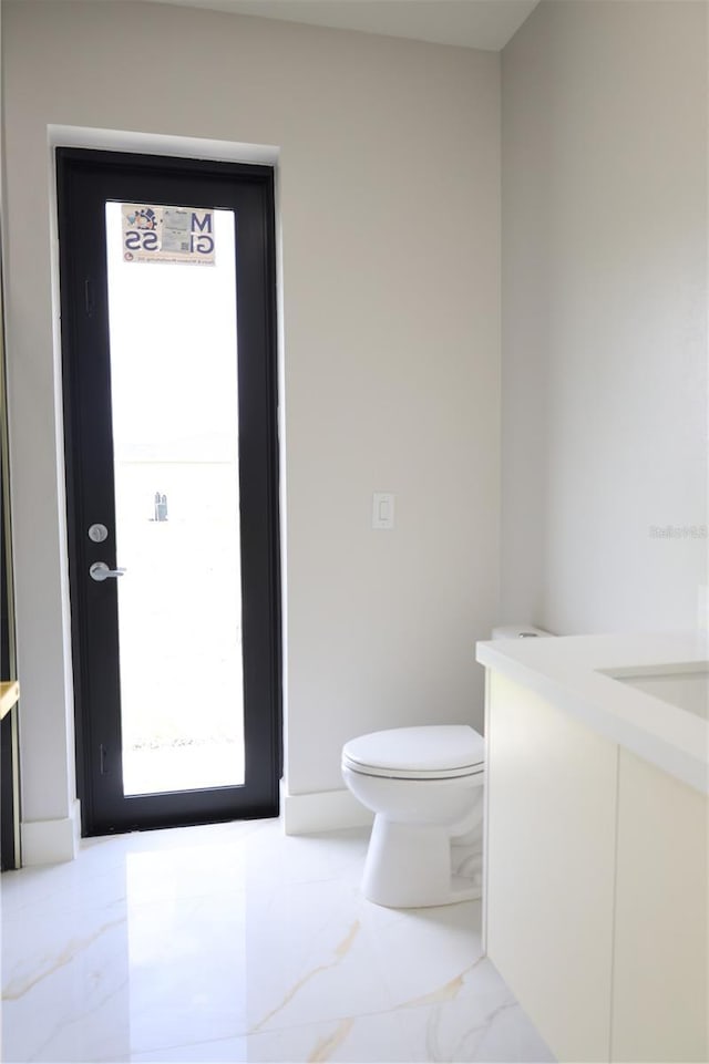 bathroom featuring vanity, toilet, and marble finish floor