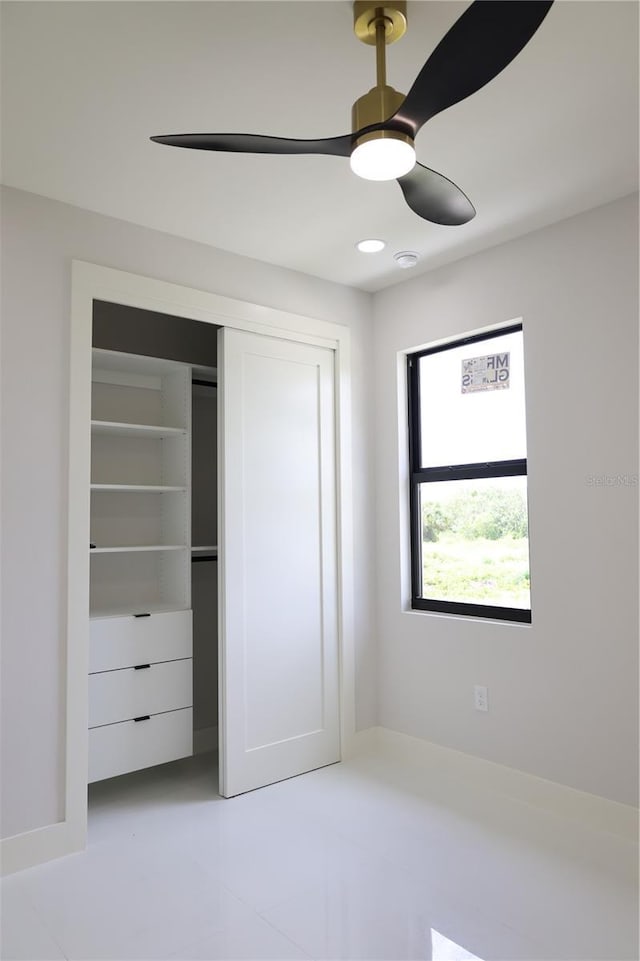 unfurnished bedroom featuring ceiling fan and a closet