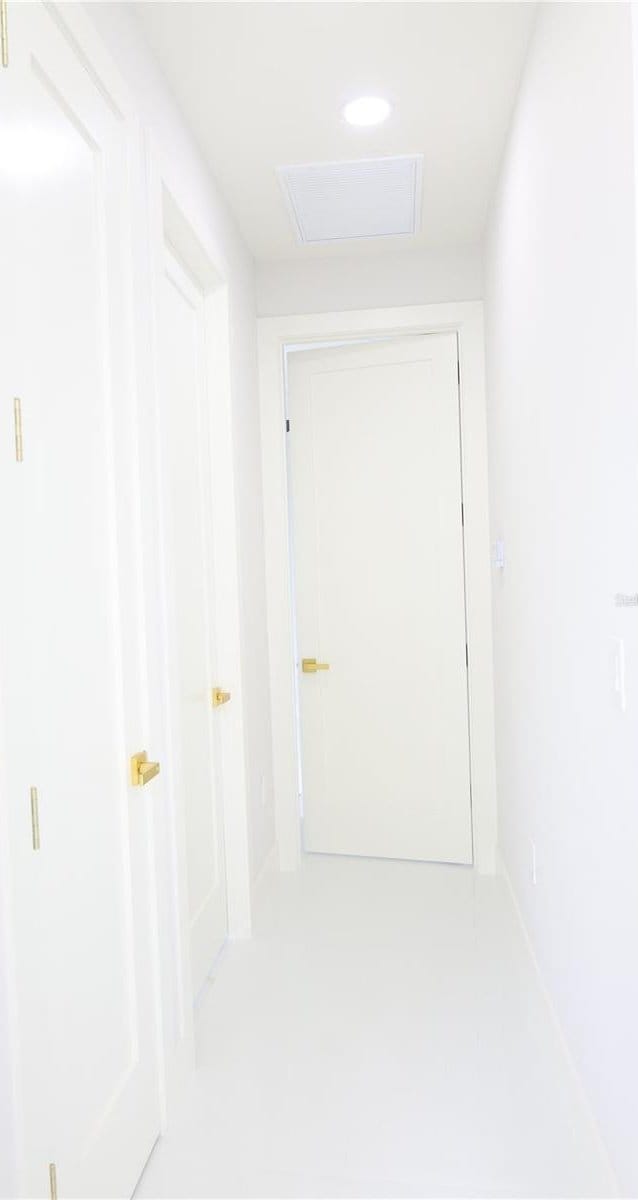 hall featuring attic access and recessed lighting
