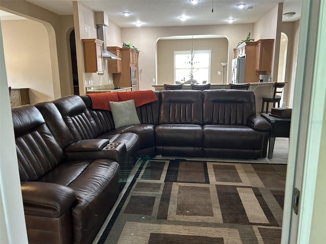 living area with an inviting chandelier and arched walkways