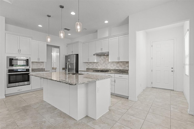 kitchen with stainless steel appliances, under cabinet range hood, backsplash, a sink, and recessed lighting