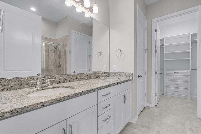 full bath with a shower stall, double vanity, and a walk in closet