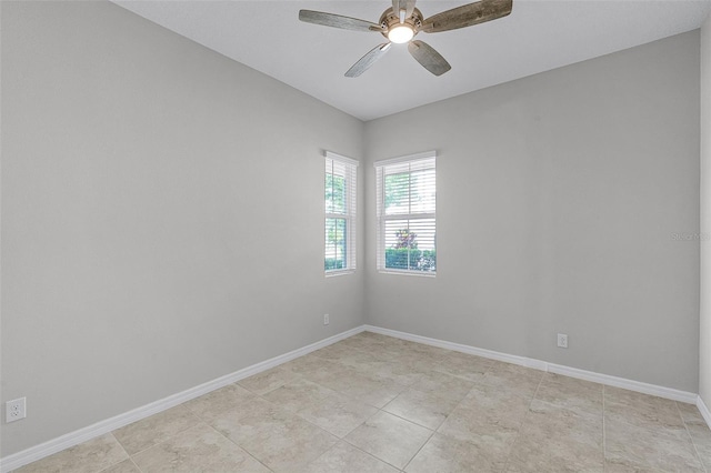 empty room with ceiling fan, baseboards, and light tile patterned flooring