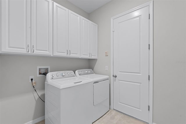 washroom featuring cabinet space, washer and clothes dryer, baseboards, and light tile patterned floors