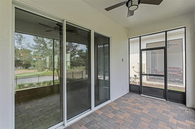 unfurnished sunroom featuring ceiling fan