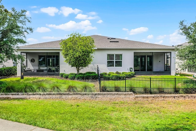 rear view of house with a sunroom and stucco siding
