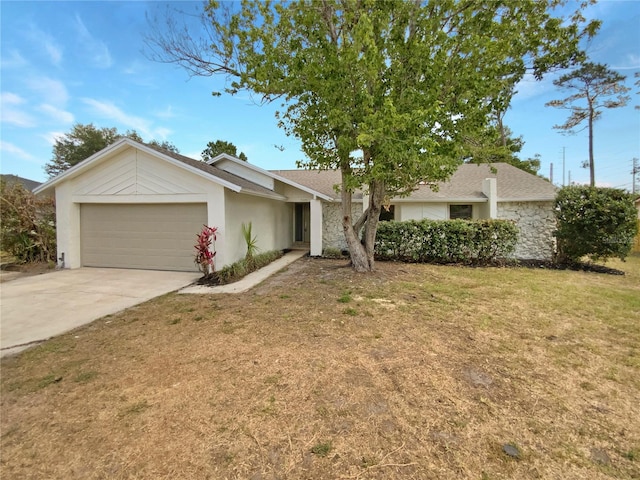 single story home featuring an attached garage, driveway, a front yard, and stucco siding
