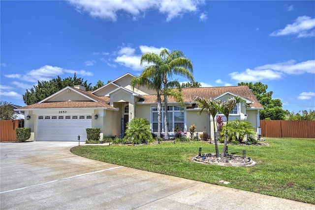 single story home with stucco siding, a garage, and driveway