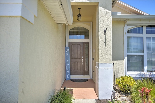 doorway to property featuring stucco siding