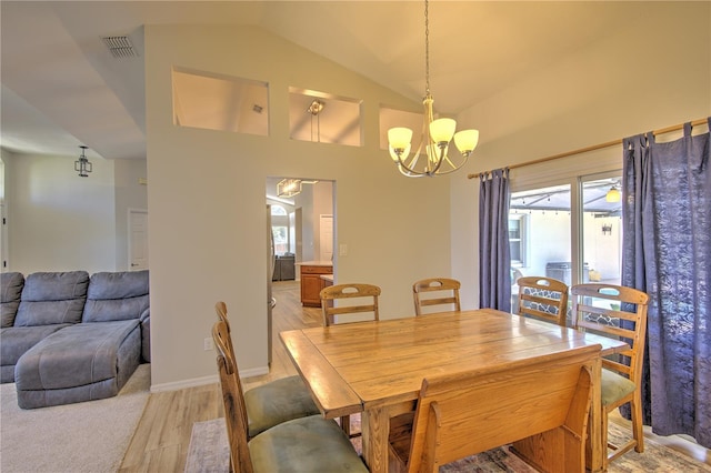 dining area with a chandelier, plenty of natural light, light wood finished floors, and lofted ceiling