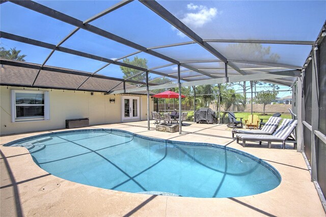 outdoor pool with french doors, a patio area, and glass enclosure