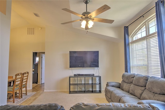 living area featuring vaulted ceiling, a ceiling fan, and baseboards