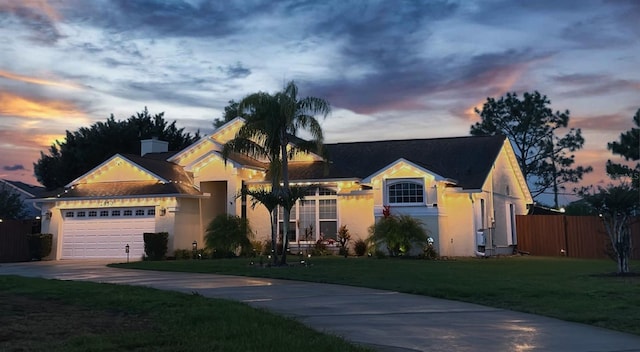 ranch-style home featuring stucco siding, an attached garage, and driveway
