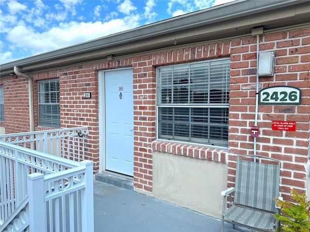 entrance to property featuring brick siding