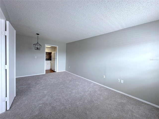 unfurnished room featuring a textured ceiling, baseboards, and dark carpet