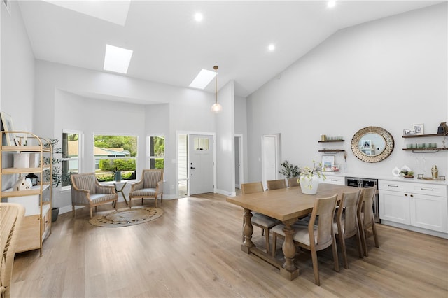 dining room with high vaulted ceiling, recessed lighting, baseboards, light wood-type flooring, and a skylight