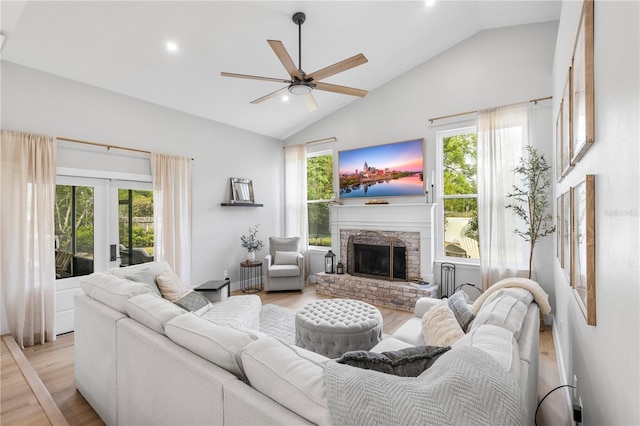 living room featuring plenty of natural light, a fireplace with raised hearth, and light wood-type flooring