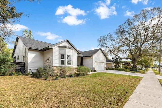 view of front of property with a garage, a shingled roof, driveway, and a front yard