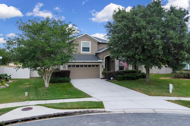 obstructed view of property with fence, an attached garage, stucco siding, a front yard, and driveway