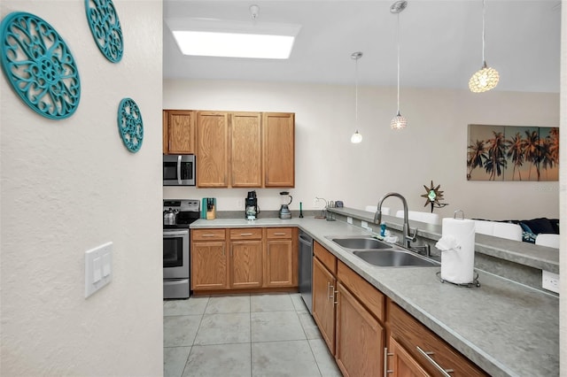 kitchen with light countertops, hanging light fixtures, appliances with stainless steel finishes, and a sink