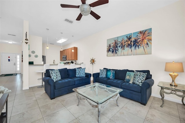 living area featuring baseboards, ceiling fan, light tile patterned flooring, and visible vents