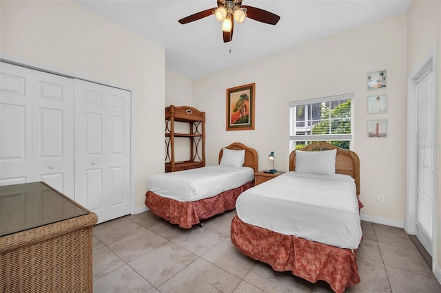 bedroom with a closet, baseboards, ceiling fan, and light tile patterned floors