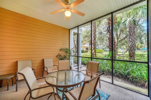 sunroom / solarium with a ceiling fan and outdoor dining area