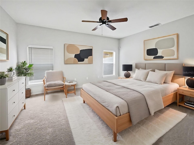 carpeted bedroom featuring baseboards, ceiling fan, and visible vents
