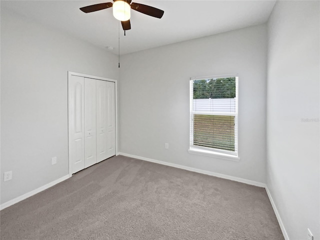 unfurnished bedroom featuring baseboards, carpet, and a closet