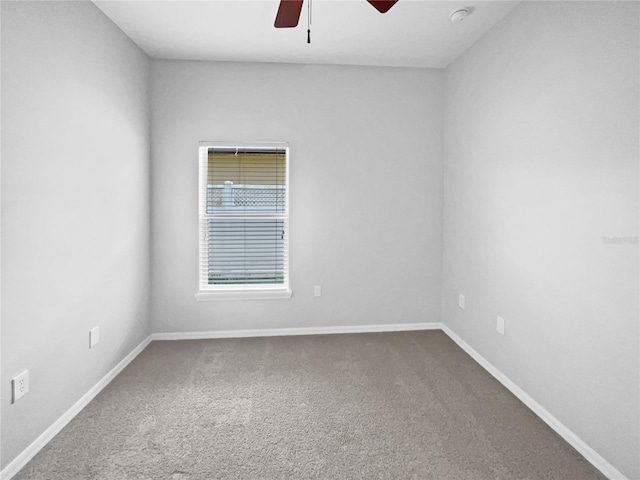 spare room featuring baseboards, a ceiling fan, and carpet