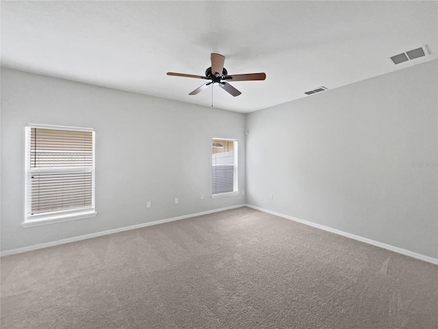 unfurnished room featuring baseboards, a ceiling fan, carpet floors, and visible vents