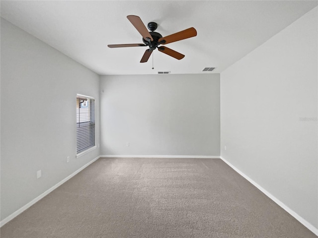 spare room with baseboards, a ceiling fan, carpet floors, and visible vents