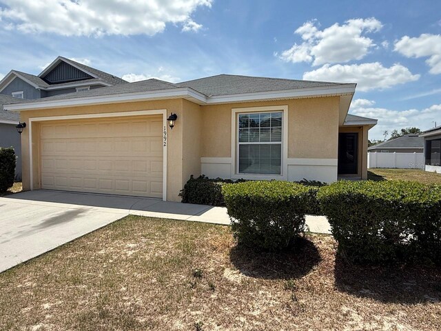 view of front of property with concrete driveway, a garage, and stucco siding
