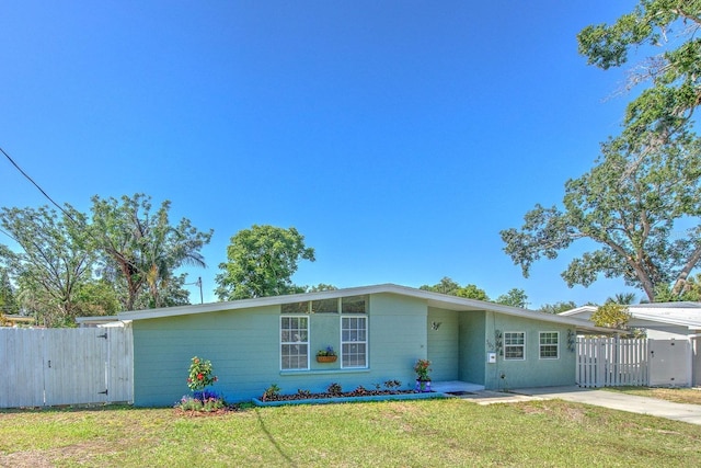 view of front of home featuring fence, a gate, driveway, and a front lawn