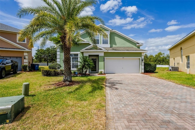 344 Cadiz Loop, Davenport, FL 33837 - view of front of home featuring decorative driveway, stucco siding, a front yard, cooling unit, and a garage
