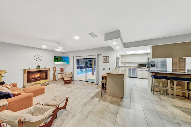 311 Needles Trl, Longwood, FL 32779 - living area featuring recessed lighting, ceiling fan, and a lit fireplace