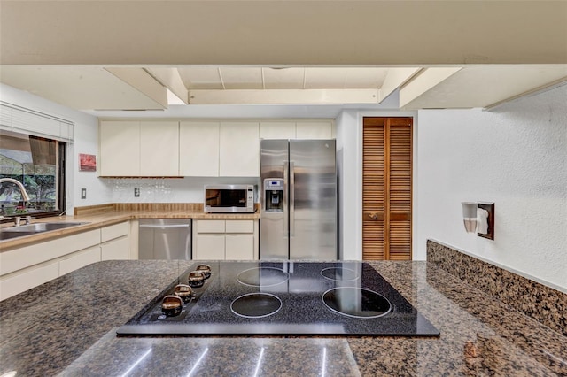 311 Needles Trl, Longwood, FL 32779 - kitchen featuring stainless steel appliances, a sink, a raised ceiling, white cabinets, and decorative backsplash