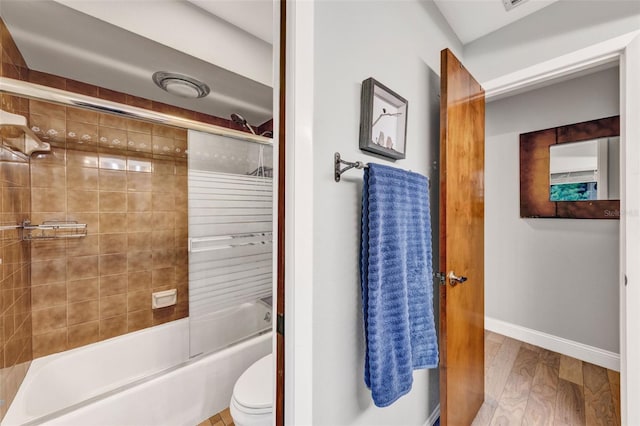 311 Needles Trl, Longwood, FL 32779 - bathroom featuring baseboards, shower / bath combination with glass door, wood finished floors, and toilet