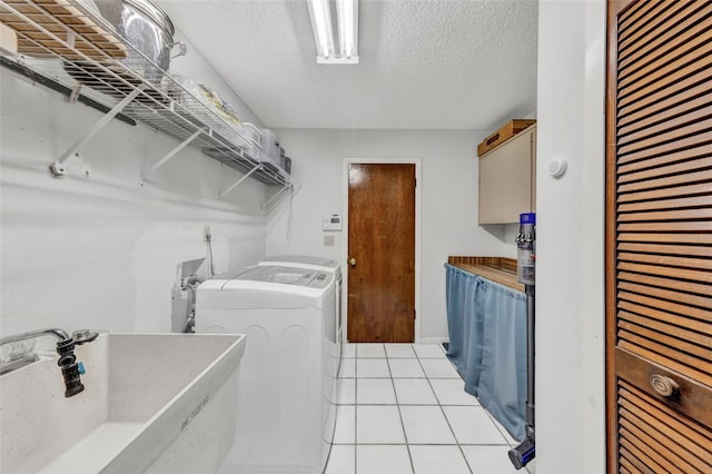 311 Needles Trl, Longwood, FL 32779 - washroom featuring washing machine and clothes dryer, light tile patterned flooring, a textured ceiling, and cabinet space
