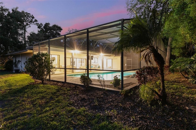311 Needles Trl, Longwood, FL 32779 - back of property at dusk with an outdoor pool, stucco siding, a lanai, and a patio