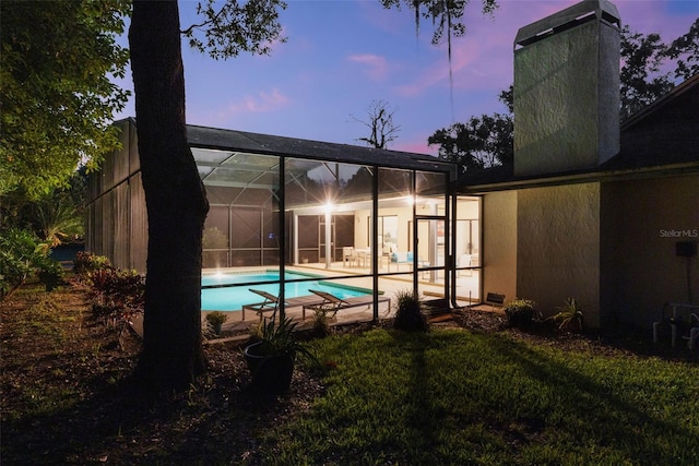311 Needles Trl, Longwood, FL 32779 - back of house featuring an outdoor pool, a patio area, a chimney, a yard, and glass enclosure