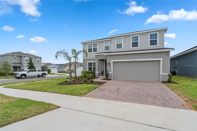 traditional-style house with a front lawn, decorative driveway, stucco siding, an attached garage, and a residential view