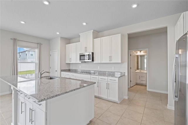 kitchen featuring a sink, baseboards, white cabinets, light tile patterned floors, and stainless steel appliances