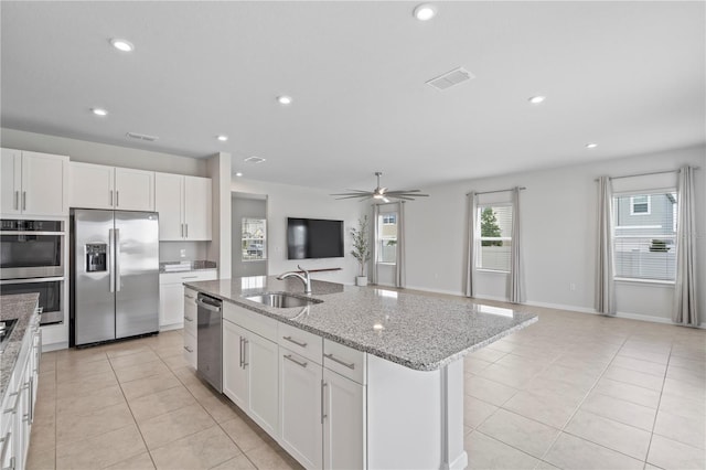 kitchen with a sink, white cabinets, stainless steel appliances, and visible vents
