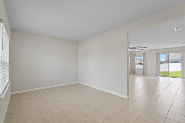 unfurnished room with light tile patterned floors, baseboards, a ceiling fan, and visible vents