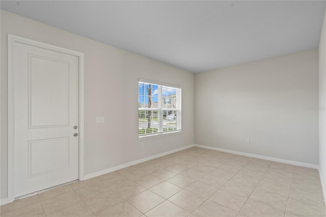 unfurnished room featuring baseboards and light tile patterned floors