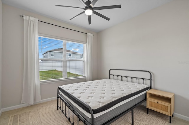bedroom featuring light tile patterned flooring, baseboards, and ceiling fan