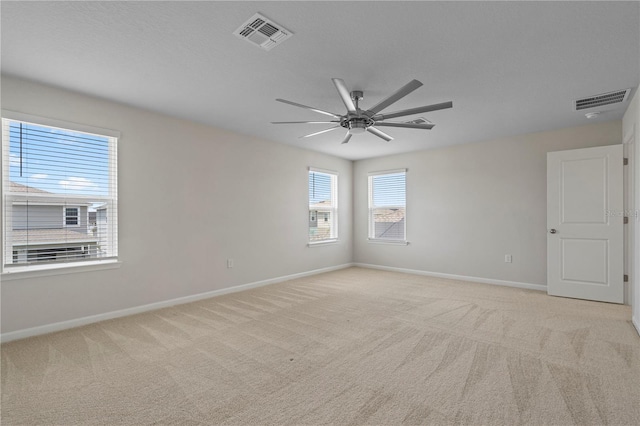 unfurnished room with baseboards, ceiling fan, and visible vents