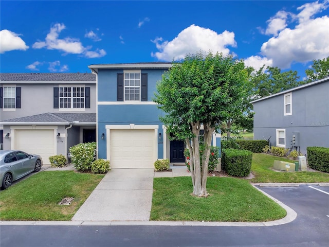 multi unit property featuring driveway, an attached garage, stucco siding, and a front yard
