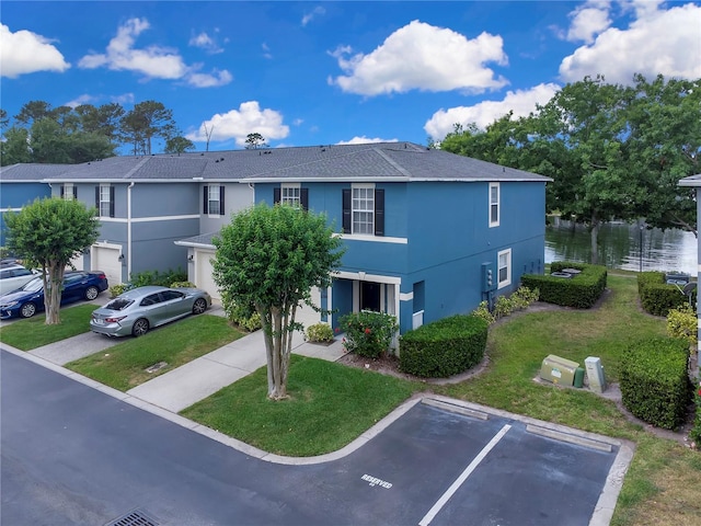 view of front of home featuring uncovered parking, a water view, stucco siding, and a front lawn